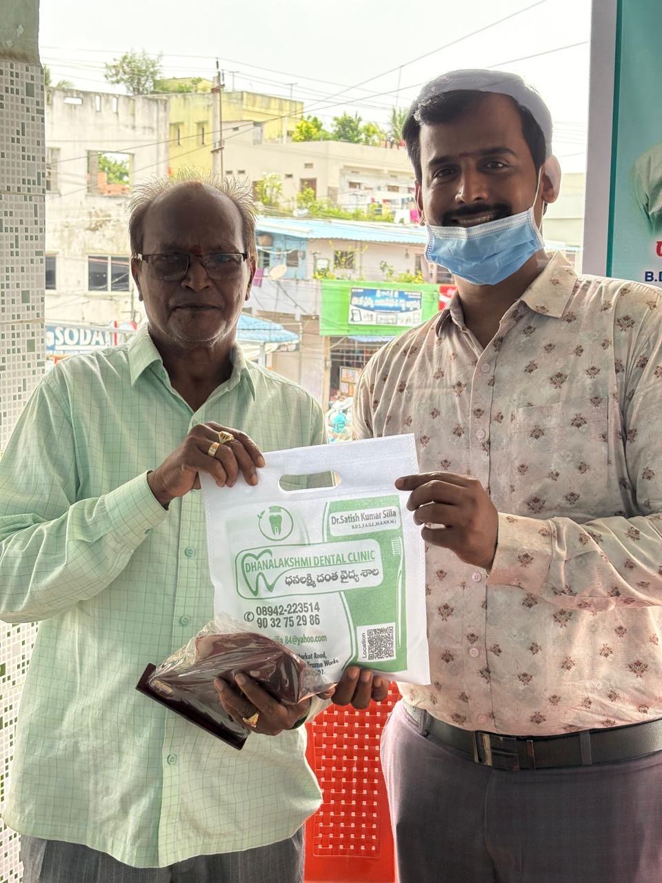 Dr. Satish consulting an elderly patient at the dental camp